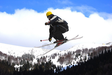 在蓝天中跳跃的自由滑雪者图片