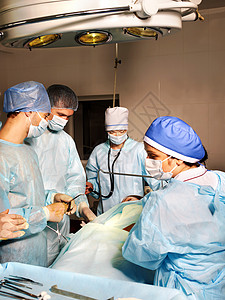 一群外科医生在手术室里看着病人图片