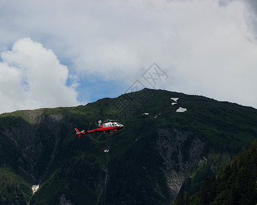 红色救援直升机在JunauAlaska附近的陡峭山图片