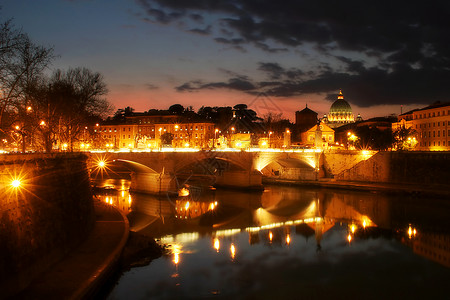 晚上从意大利罗马的圣天使桥照亮梵蒂冈城泰伯河图片