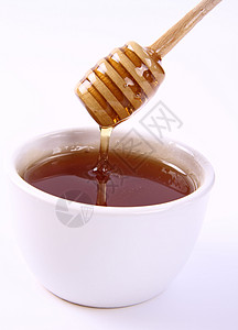 白色背景中碗里的蜂蜜背景图片
