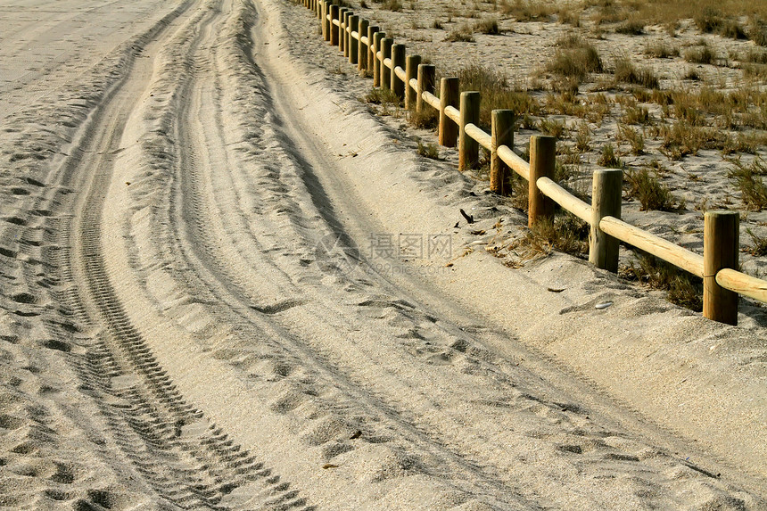 沙路上车轮的痕迹右边的木栅栏图片