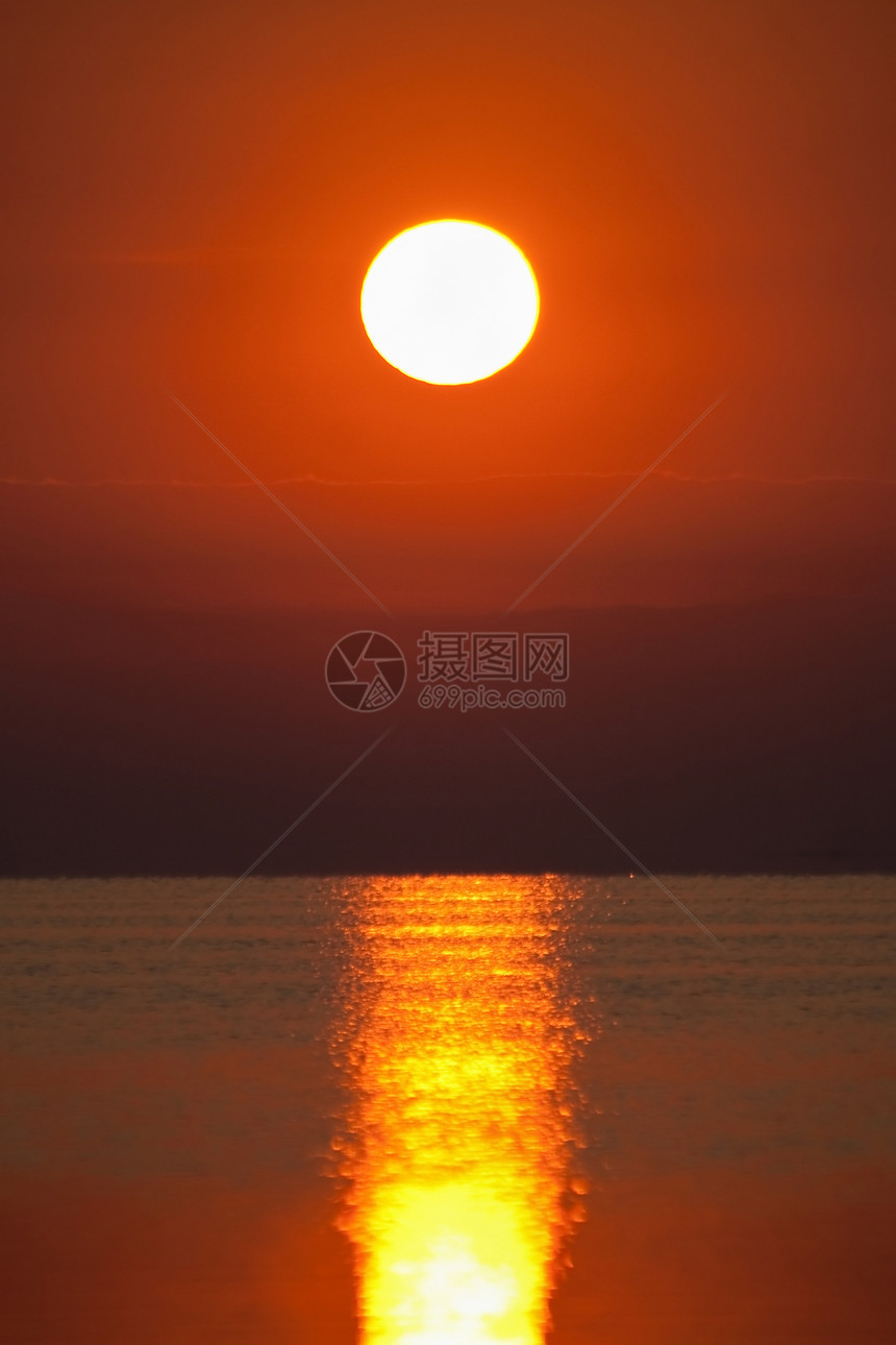 在平静的海面上的红色日落图片