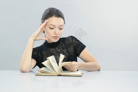 年轻女学生阅读并翻书页图片