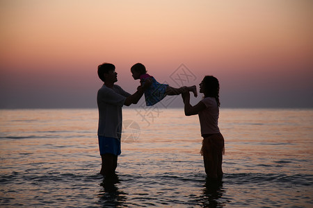 夕阳下海中的一家人图片