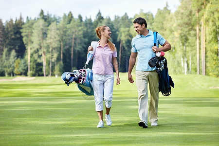 高尔夫球场上的年轻夫妇图片