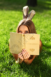 公园草地上看书的女人图片
