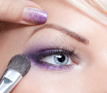 化妆师应用美丽的化妆眼影图片