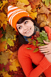 秋天橙色叶子的女孩户外的图片