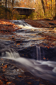 秋天一座廊桥下的急流和溪流背景图片