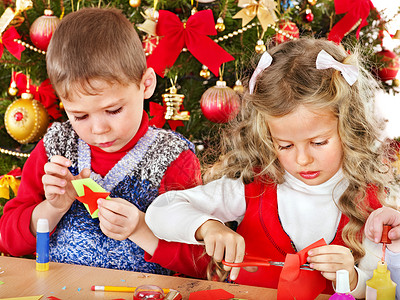 男女儿童为圣诞节做装饰品图片