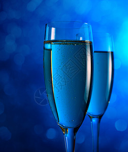 蓝色背景的酒杯中的香槟图片