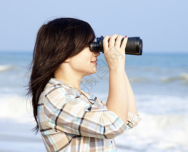在海滩上戴双筒望远镜的女孩图片