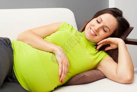 笑脸孕妇躺在沙发上图片