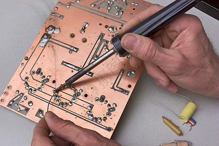 电子实验室技术人员用铁焊锡线修复电子管图片