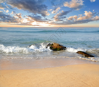 海洋岸波浪中的美丽石头图片