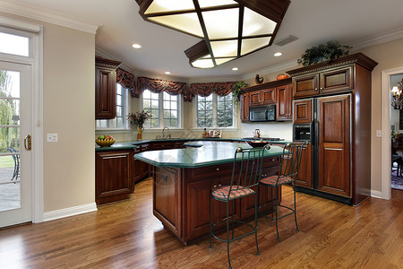带深色木柜和绿色岛台的厨房背景图片