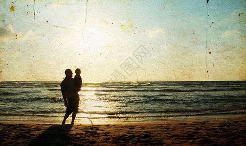 父亲和儿子在海上观看日落照片以旧图片