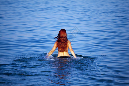 美丽的年轻女子在海上泼水夏天高清图片