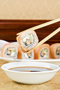 手拿寿司用筷子在桌上图片