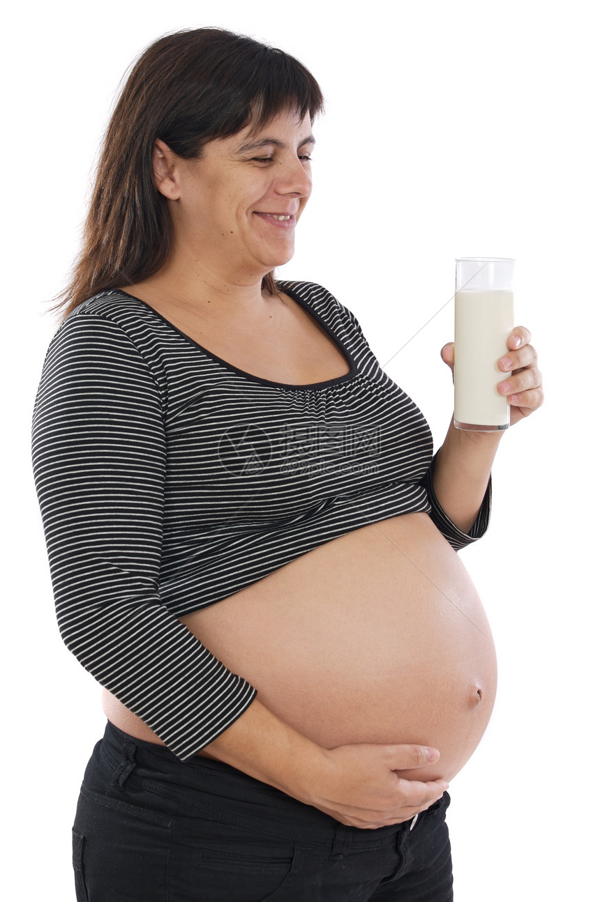 怀着一杯牛奶的漂亮孕妇在白图片