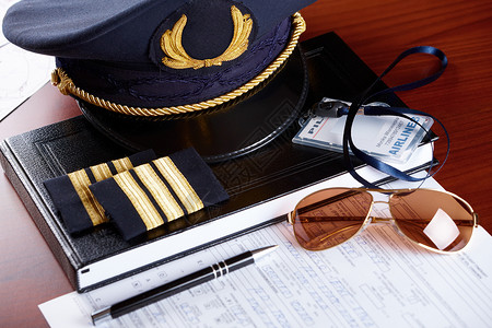 专业航空飞行员帽和挂有墨水和太阳眼镜的持单人图片