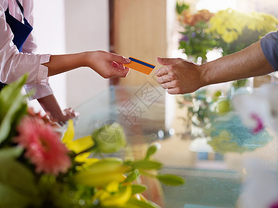 作为花店的年轻女青年在购买后向客户发放信用卡横向图片