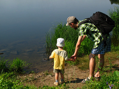 父亲和儿子在河边手牵年轻家庭在图片