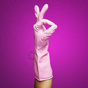 粉红色橡胶手套在粉红背图片