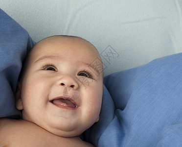 刚出生的婴儿躺在蓝色的毯子上特写图片