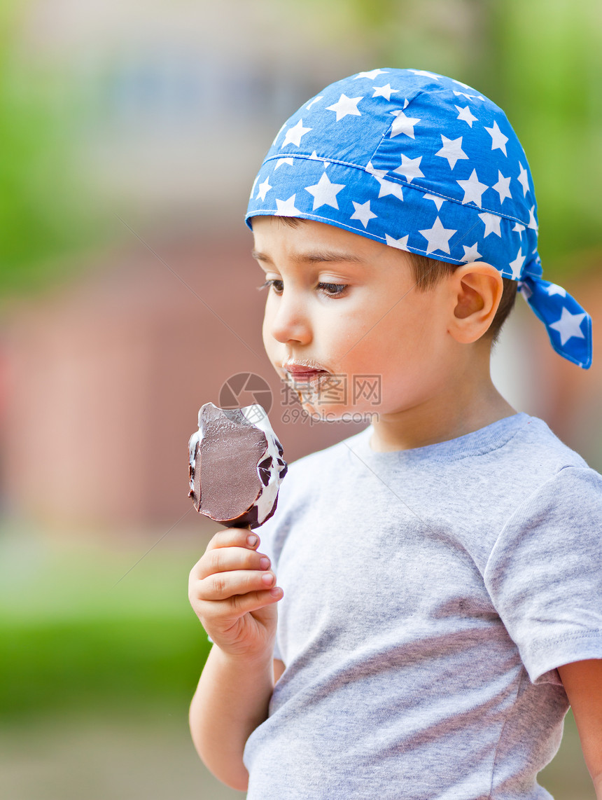 头巾的可爱小男孩吃冰淇淋图片
