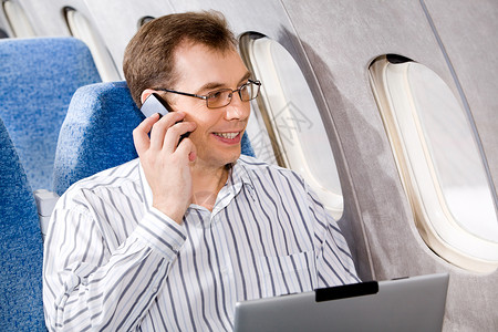 商人在飞机上通过电话图片