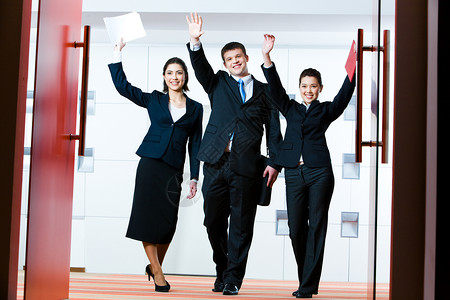 成功的商业集团站在会议厅门口举手问候合图片