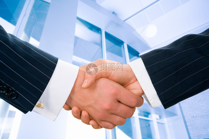 商业人士在办公大楼背景上的握手形象单图片