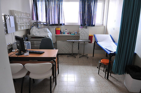 有空桌子椅子和一张床的医院诊所室图片