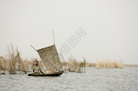 妇女乘船在贝宁矮人Ganvie图片
