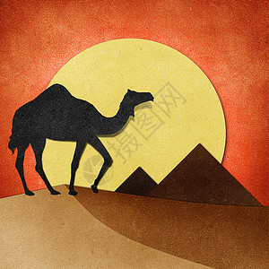 沙漠回收纸工艺品上的骆驼和金字塔背景图片