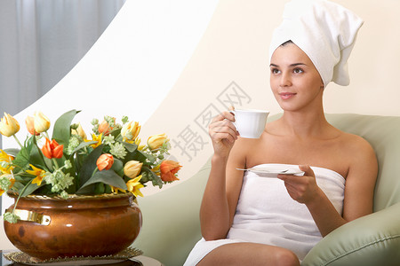在美容院里喝茶穿着毛巾的干图片