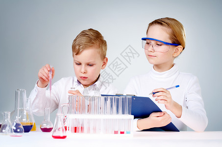 一个小男孩混合化学液体和助手图片