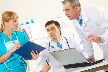 年长的医生和年轻临床医生用护士手看文件的照片AC549图片