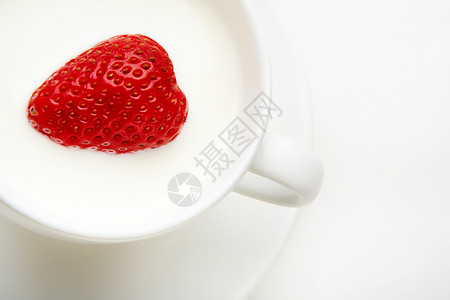牛奶杯中心形草莓的特写图片