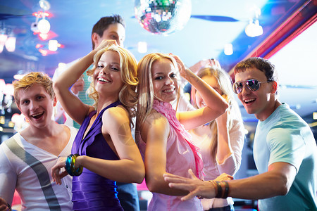 在派对上跳舞的欢快女孩和身边快乐的朋友一图片