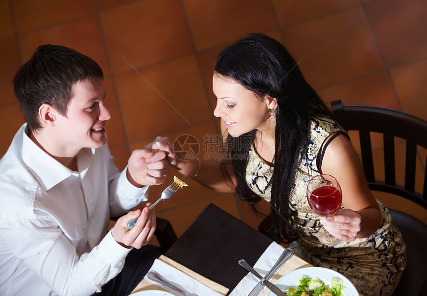 幸福的夫妇在晚餐时吃东西的上方视图图片
