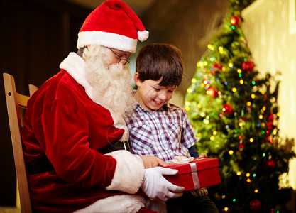 照片可爱男孩和圣诞老人拿着礼图片