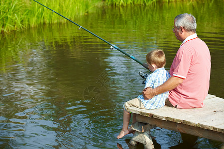祖父和孙子在周末坐在浮舟上钓鱼的照片图片