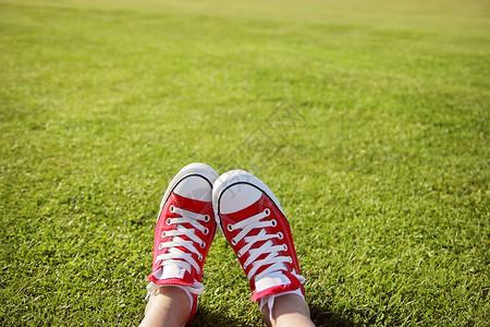 脚穿运动鞋在绿草丛中图片