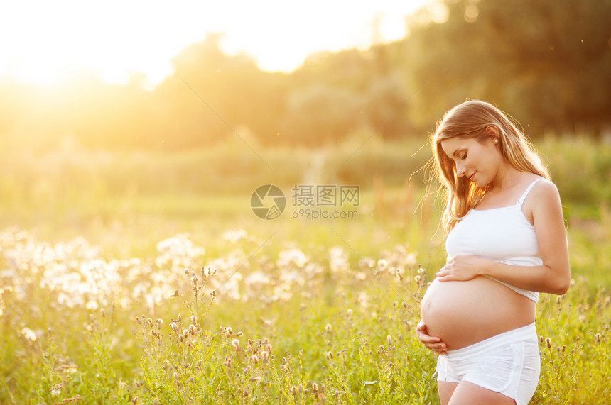 美丽的孕妇在公园外面放图片