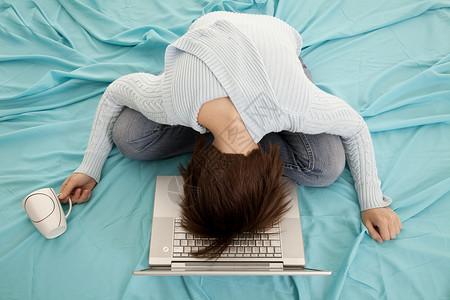 一个女人躺在床上头朝下躺在电脑上图片