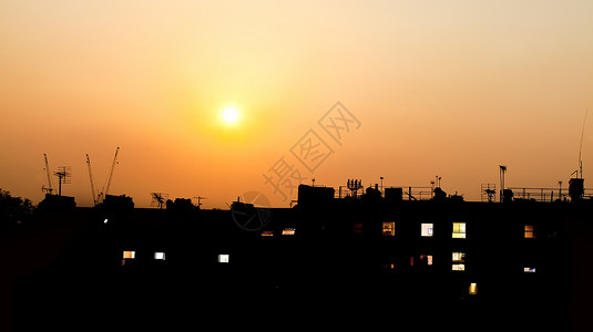 屋顶上的日落建筑物的灯光透过窗户照耀图片