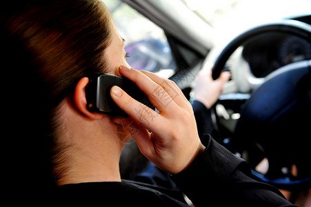 一名女驾驶员开车时在手机上讲图片